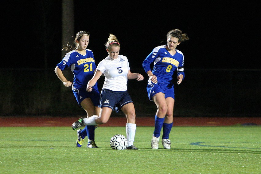 Out-of-Door Academyâ€™s Abby La Gasse prepares to the pass the ball as Canterburyâ€™s Tegwyth Alderson-Taber, No. 21, and Dietta Hahn, No. 9, try to steal the ball.