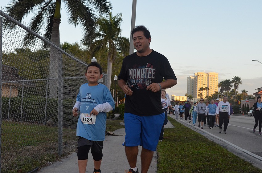 Isaiah Jackson, 7, runs with his father Sergio. Isaiah was hit by a dump truck and laid in a coma for 3 weeks. Sergio is grateful to see his son run today after relearning how to walk.