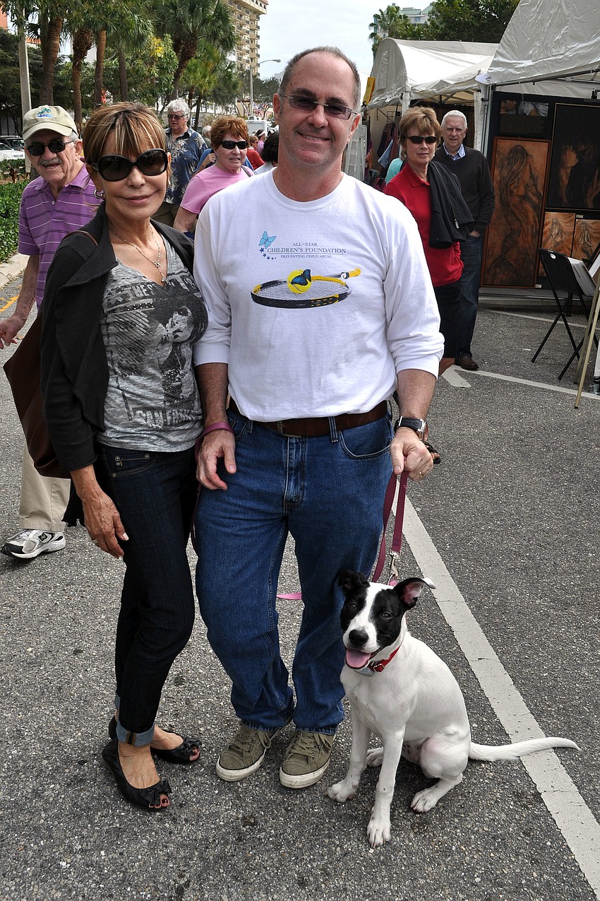 Chris and Kirk Voelker with their 6-month-old puppy, Lucy. Lucy was adopted from the Humane Society of Sarasota County.