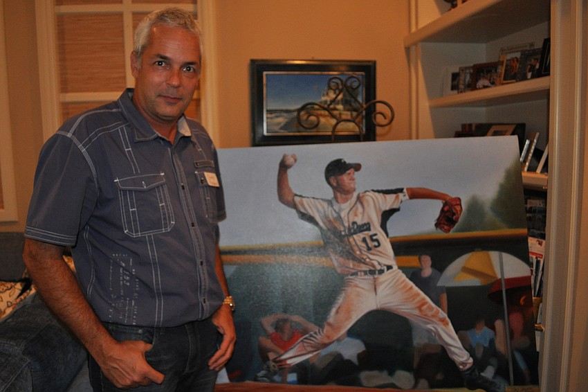Artist Clark Prosperi stands with the portrait he completed for the Emmons family.