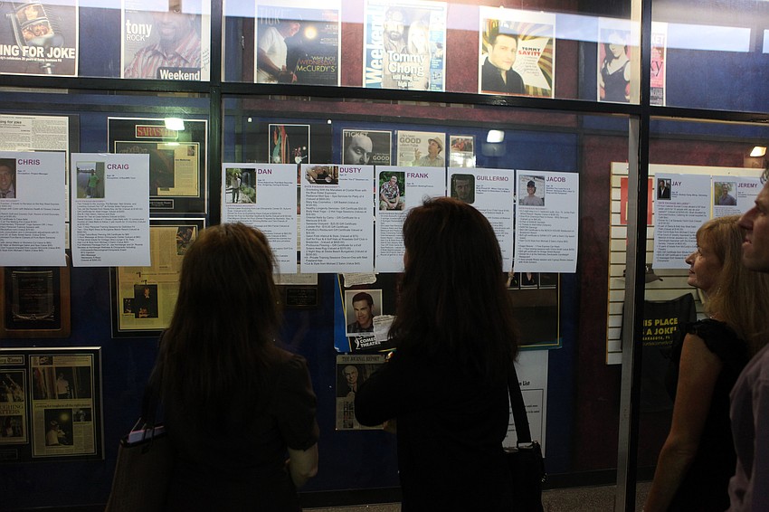 People attending the third annual BYOBachelor Auction look at the photos, packages and info about the bachelors up for auction Tuesday, Sept. 18.