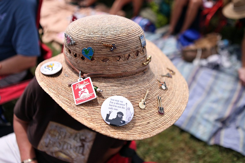 Barbara Penny shows off her hat that is decorated with pins that she picks up at each music festival she attends.