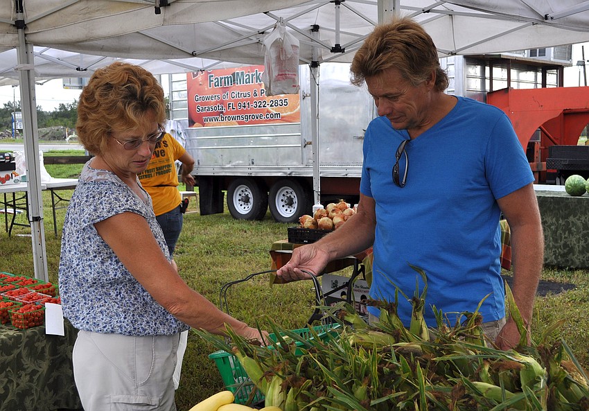 Lynn and Mike Martin look for a variety of produce at Brownâ€™s Groveâ€™s tent at the Phillippi Farmhouse Market.