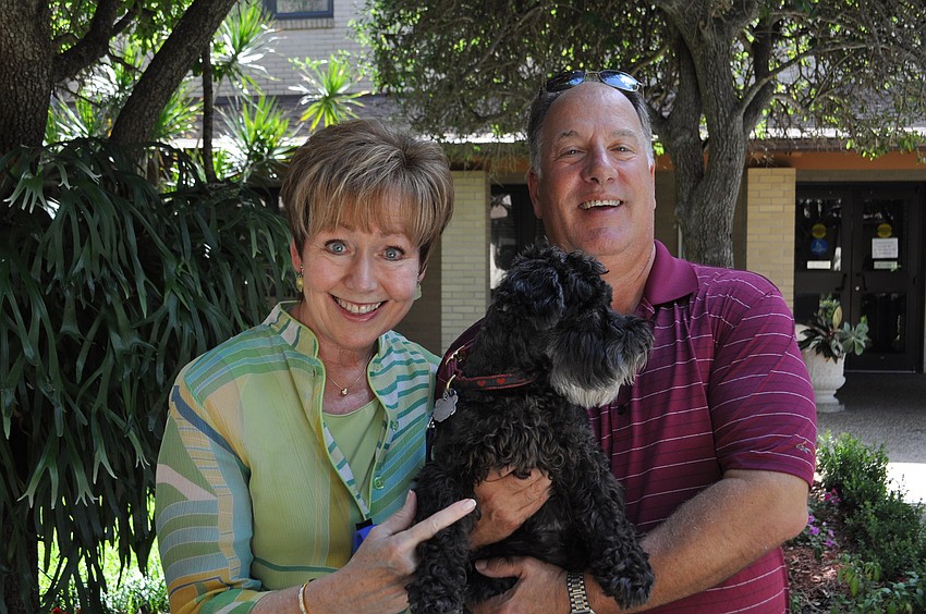 Peg and Leo Latini hold their dog, Holly.
