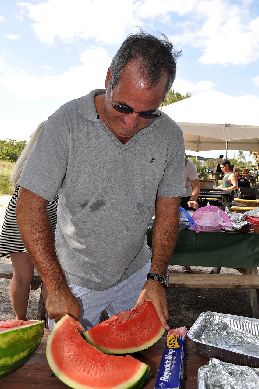 Dan Kriwitsky cuts up watermelons for the beach bash.
