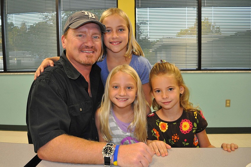 Dave Buck and his daughters, Sydney, center, and Rachel, behind, ate doughnuts with friend, Olivia Blank, right.