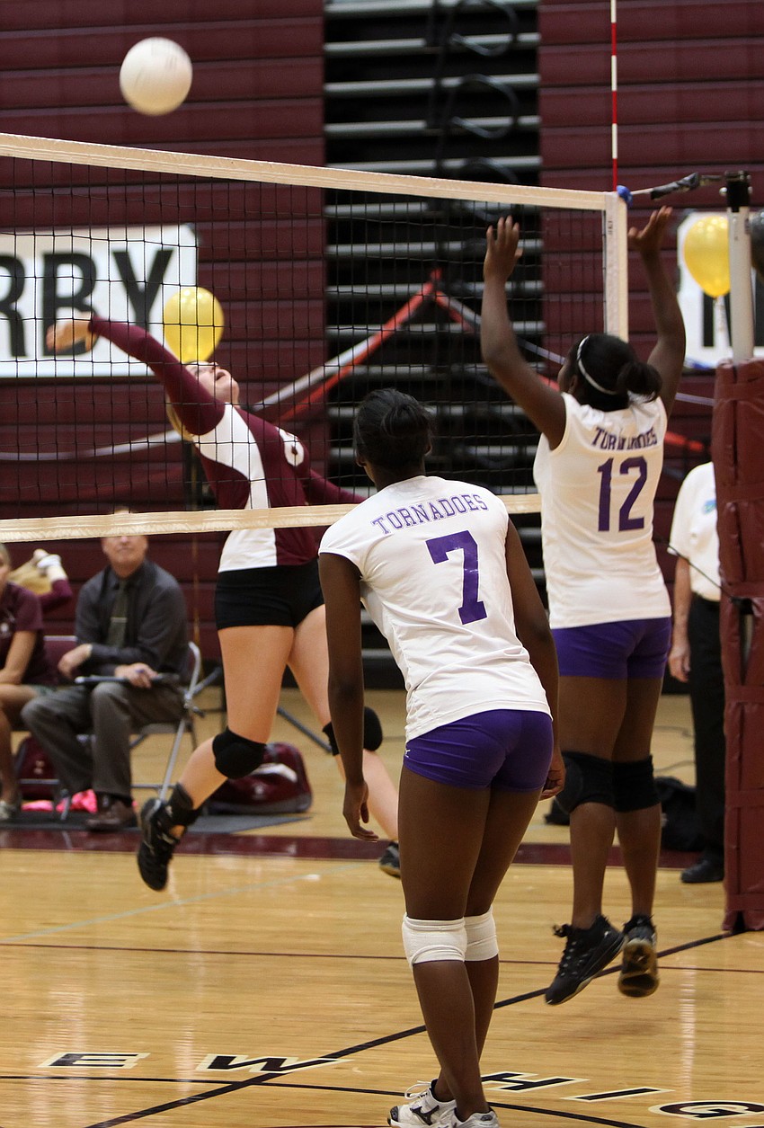 Darby Tingle, No. 8, goes up to spike the ball as Shakaria Ige, No. 7, and Kellisha Bellamy, No. 12, prepare to try and stop Riverview from scoring.