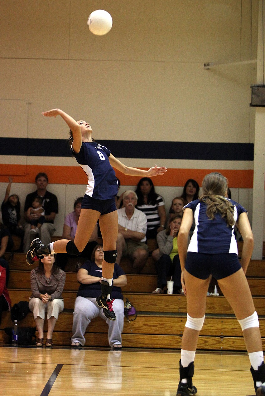 Lauren Maxey, No. 8, jumps up to spike the ball over the net.