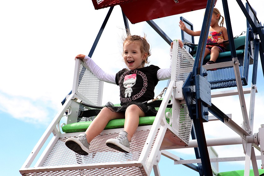 Rylan Meredith, 3, laughs and smiles at her family as she rides the Ferris wheel Saturday, Oct. 27.