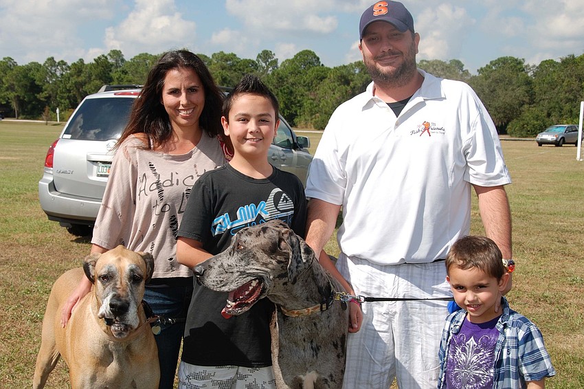The Rich Family and their Great Danes cheerfully gather together for a family photo.