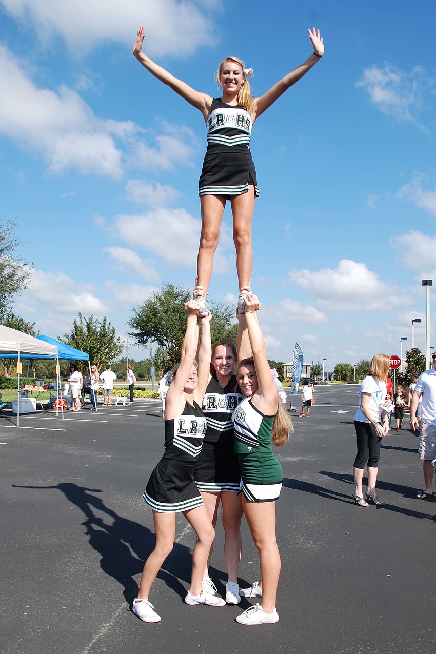Members of the Lakewood Ranch High Schoolâ€™s varsity cheerleading team do a stunt for spectators.