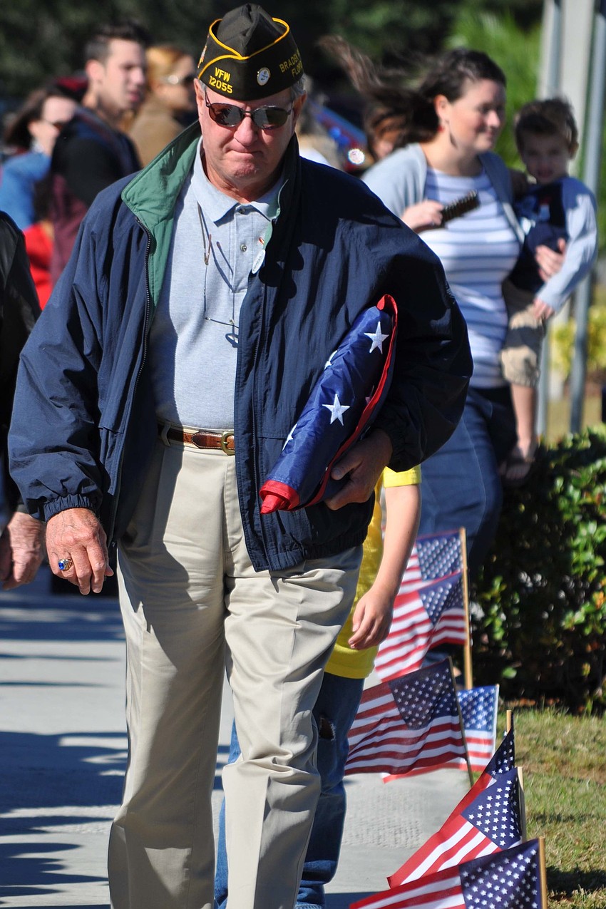 Veterans Dennis Merriman and Denny King raised the American flag with the help of two Freedom Elementary School students.