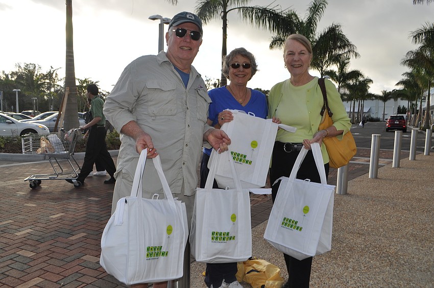 Stuart and Joy Kramer and Joan Jordan with their purchases on opening day. They bought fruit, yogurt and toothpaste but plan to return for more.