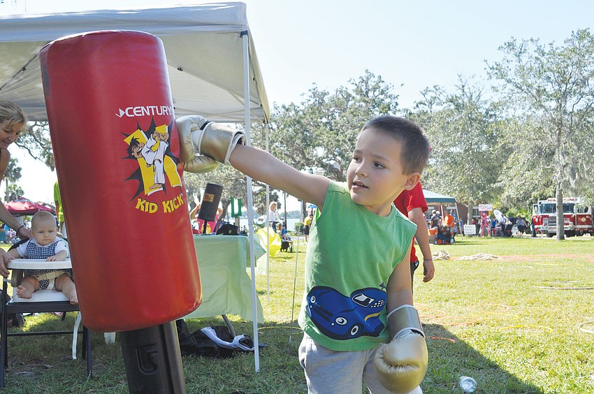 Joseph Grossi punches a punching bag at the fitness station at the Fall Family Festival hosted by the Conservation Foundation of the Gulf Coast.