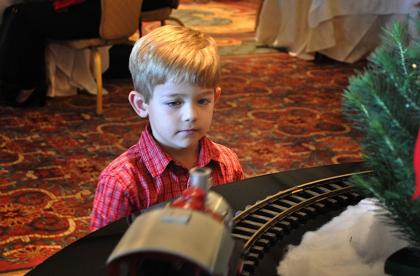 Tyler McCoy, 4, watches the electric, toy train make its way around the track.