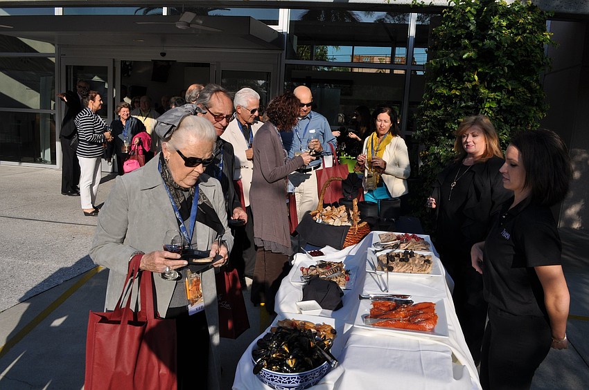 People choose some food from the table in the Oregon/Washington region of the Wine Walk.