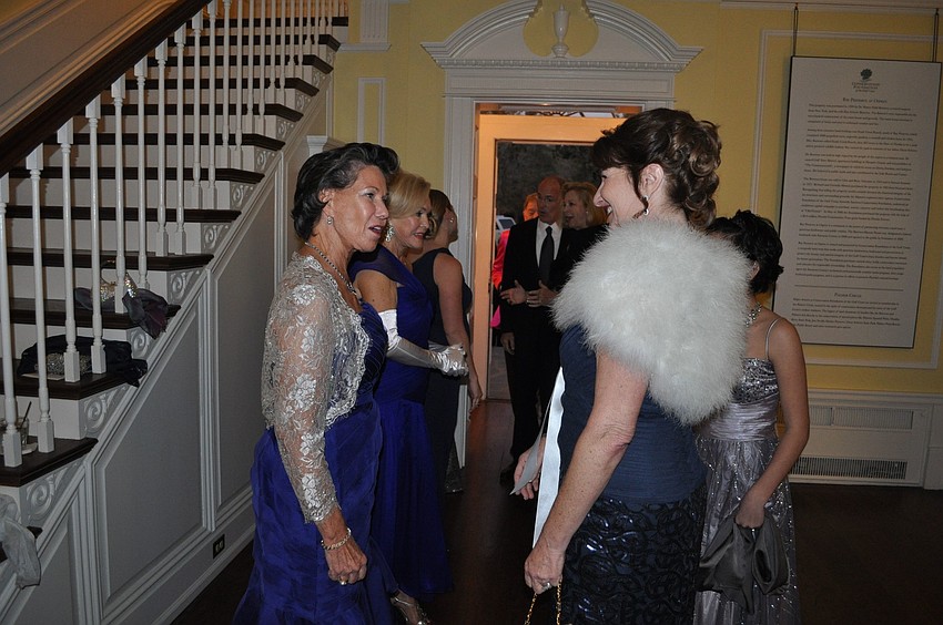 Chairwomen greet their guests inside the mansion.