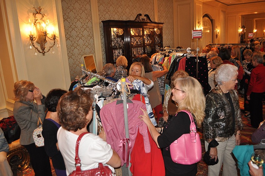 Women look through racks of clothing from the Treasure Chest.