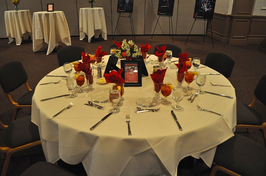 The tables were decorated with red napkins, a vase of flowers and framed photos of different Girls Inc girls.