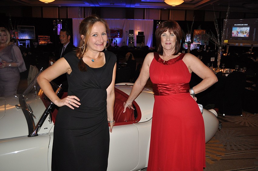Deanna Ferguson and Betsy Bowman pose in front of the 1959 MGA 1500 Roadster that was up for auction.