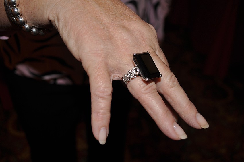 The 18k white gold ring with emerald cut onyx center stone set on a signature oval diamond Pave band was the item those attending the luncheon could win in a chance drawing.