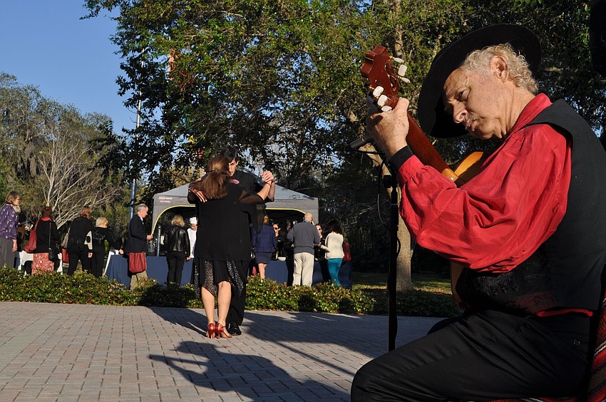 Pablo Salatino and Aya Konstantinou dance while Juan de la Sierra plays his guitar in the Argentina region.