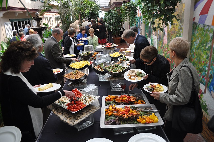 Guests make their way around the courtyard, filling their plates with food for brunch.