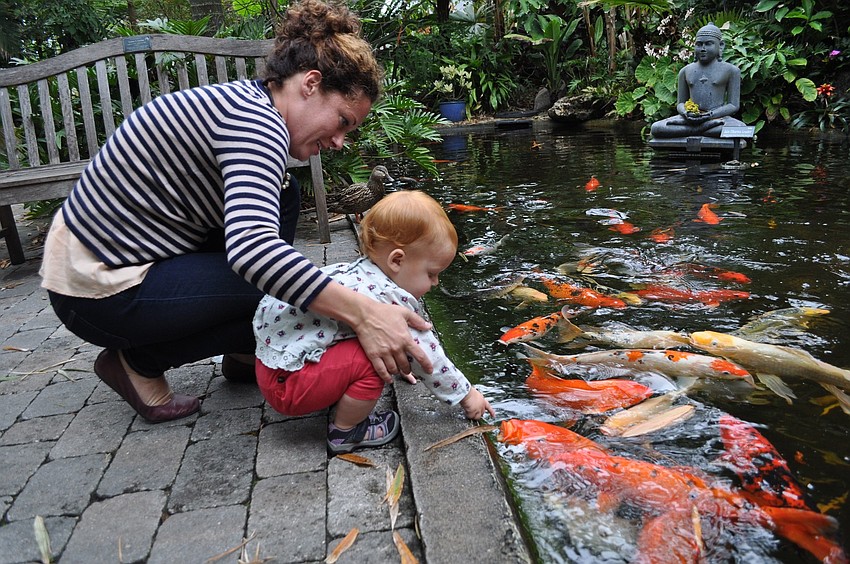 Mindy Rollins and her daughter, Eve, have fun at the koi pond.