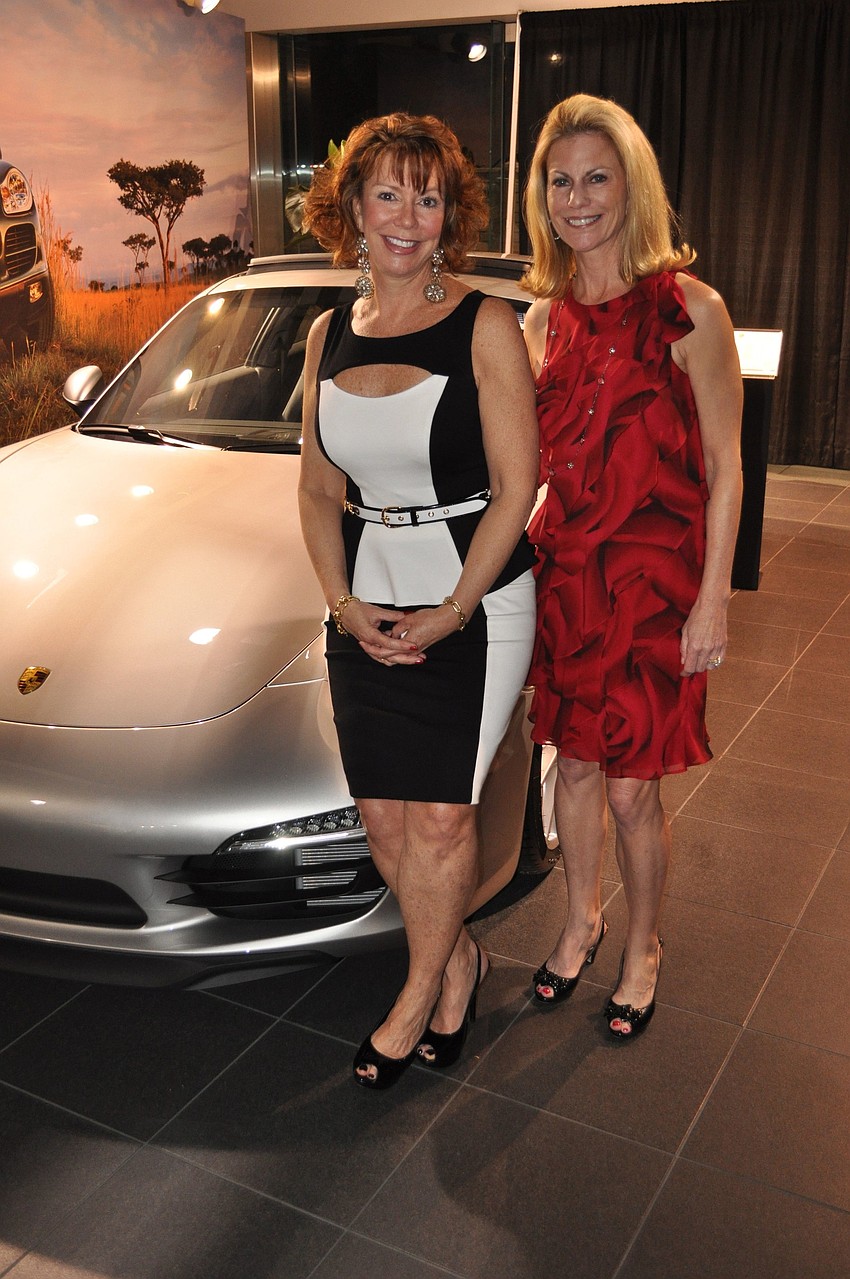 Chairwomen Donna Simmons and Jackie Dickinson pose by one of the Porsches.
