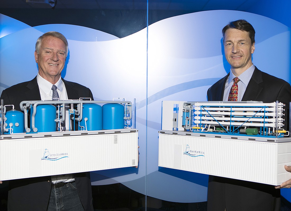 Mark Wemple. AquaVenture executives Doug Brown, left, and Olaf Krohg display scale models of the company&#39;s water desalination plants that can fit inside shipping containers.