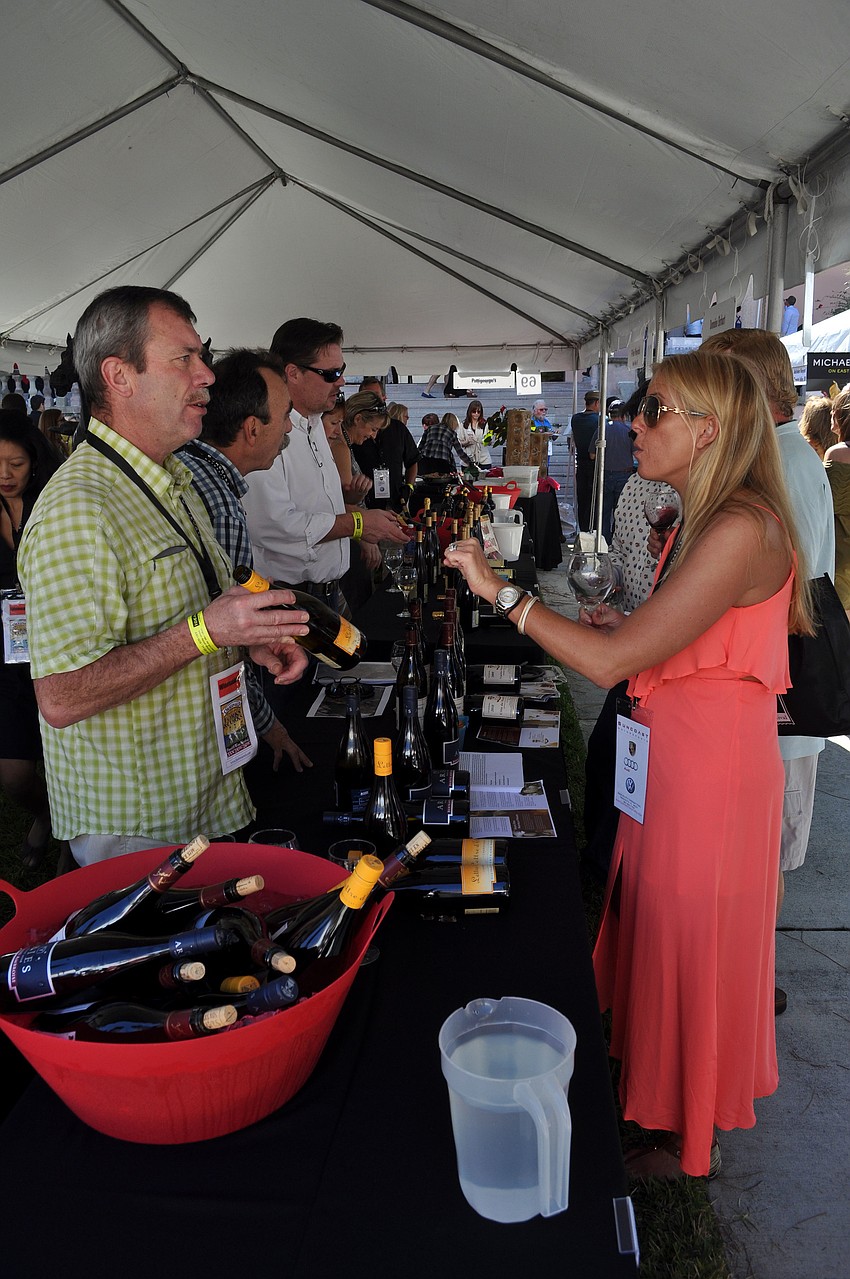 People lined up under tents to try different wines