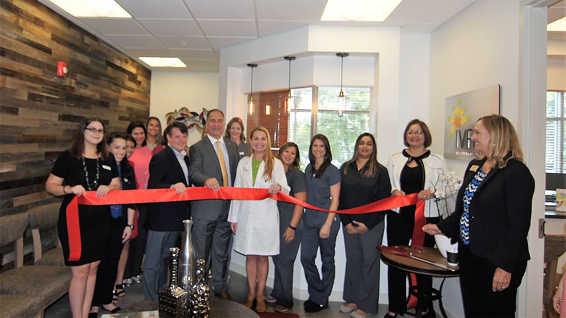Naples IVFMD center lead physician Dr. Connie Alford is joined by members of the practice, Collier Board of County Commissioners Chairman Andy Solis, Arthrex Vice President Dan Hall and others to cut the ribbon.