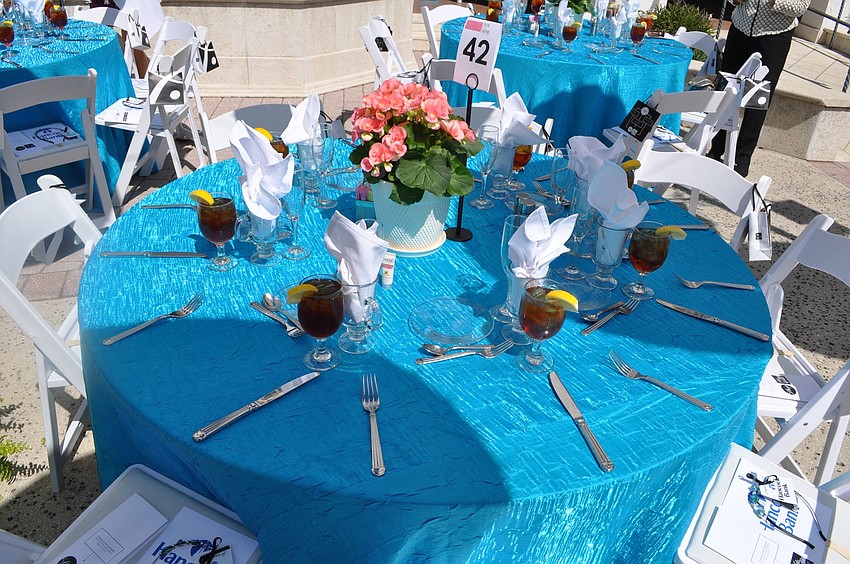 The tables were set with bright blue table clothes and potted flowers in red, pink and yellow.