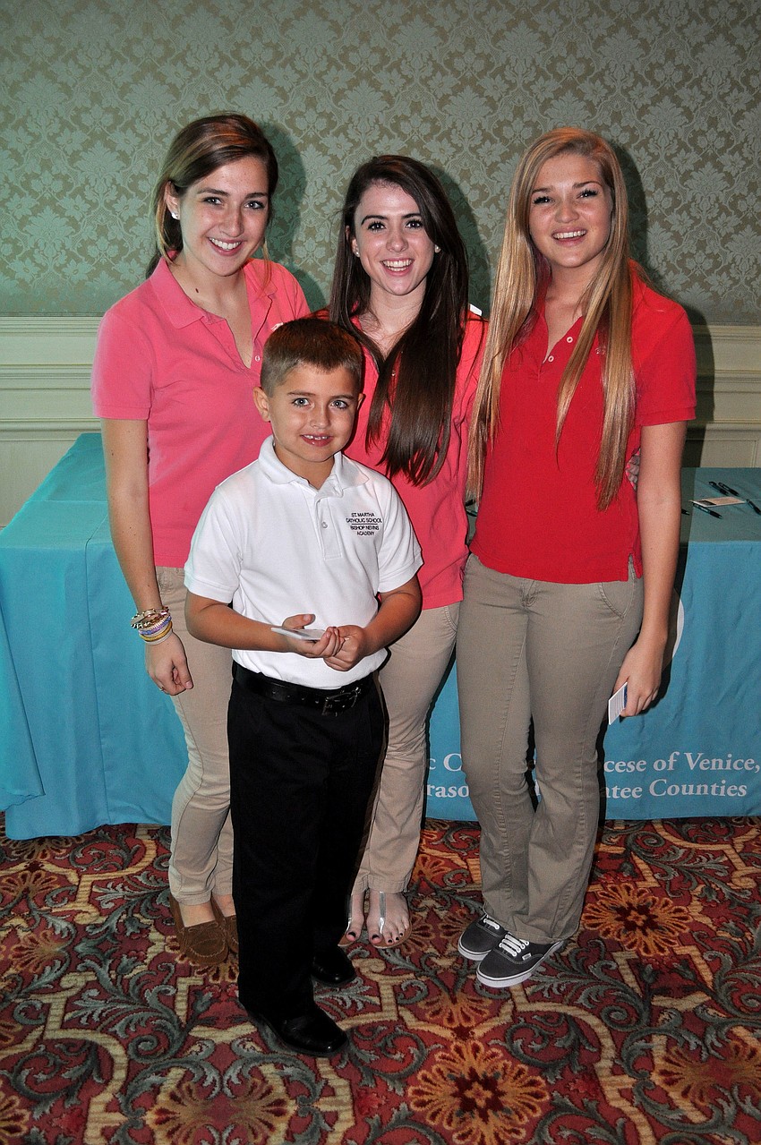 Katherine Liebold, 16, George Liebold, 7, Daniella Spina, 15, and Olivia Little, 15, sold raffle tickets Saturday, Jan. 26, at the Catholic Charities Ball.