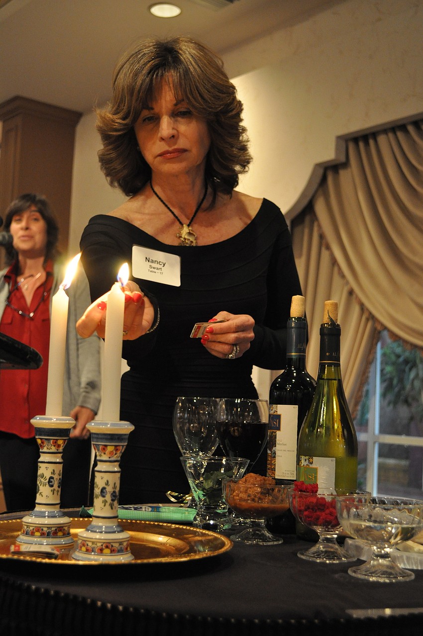 Nancy Swart lights the candles.