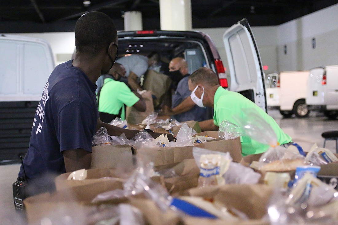 Halifax Urban Ministries volunteers load vans full of groceries for families in need. File photo from October 2020