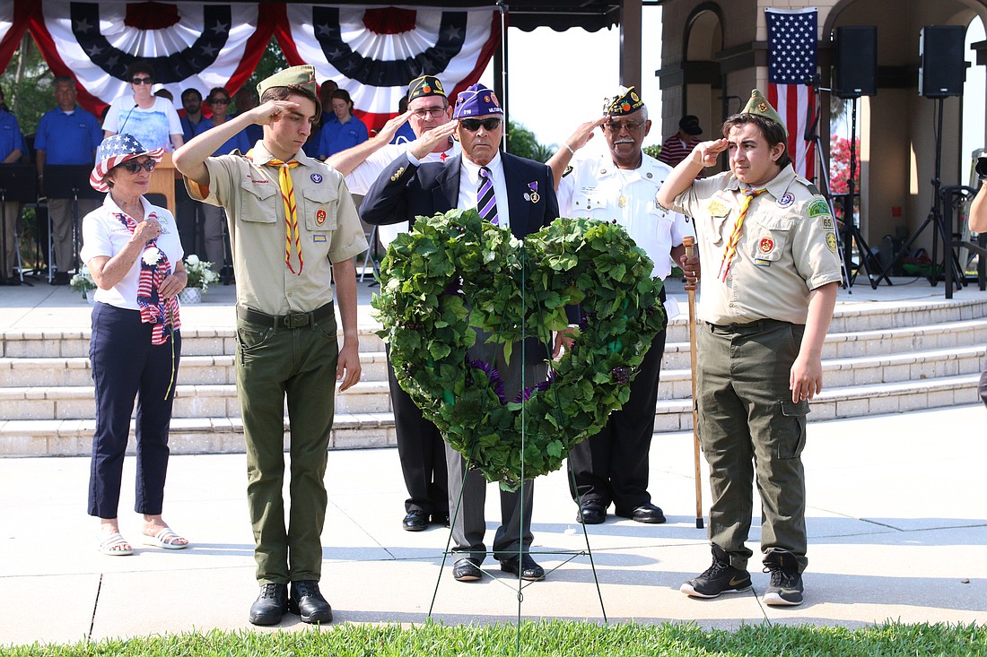 Rolf Mattar, of the Military Order of the Purple Heart, salutes the wreath with two boy scouts during the city's Memorial Day remembrance service at Rockefeller Gardens on Monday, May 27. File photo