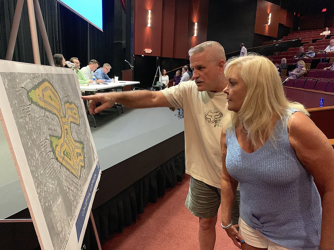 Paulette Boyer and Steve Pettenger examine the conceptual plan for the development. What did Pettenger see" "Ugliness," he said. Photo by Brian McMillan