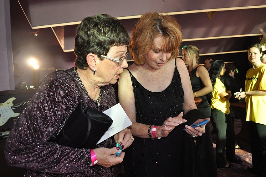Sandy Dietrich and Pat Shea try to bid on something using the BidPal device.