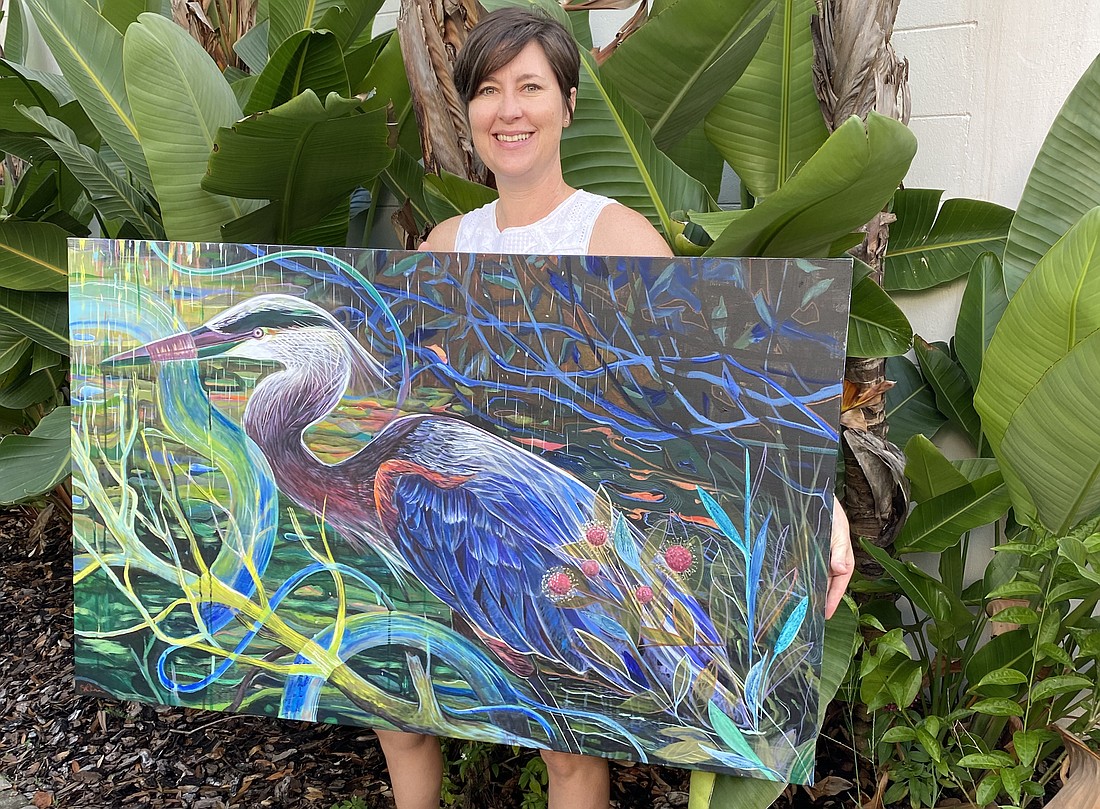 Beth O'Connor holds her painting, titled "Interconnected." Courtesy of OMAM