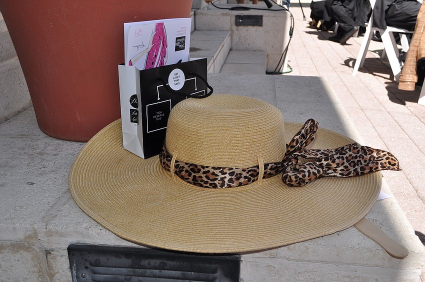 A woman's hat with a small goodie bag from Saks Fifth Avenue.