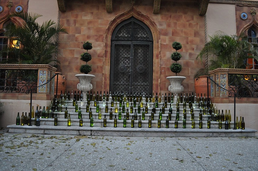The steps to the front door of the Caâ€™ dâ€™Zan were decorated with wine bottles with small lights inside of them.