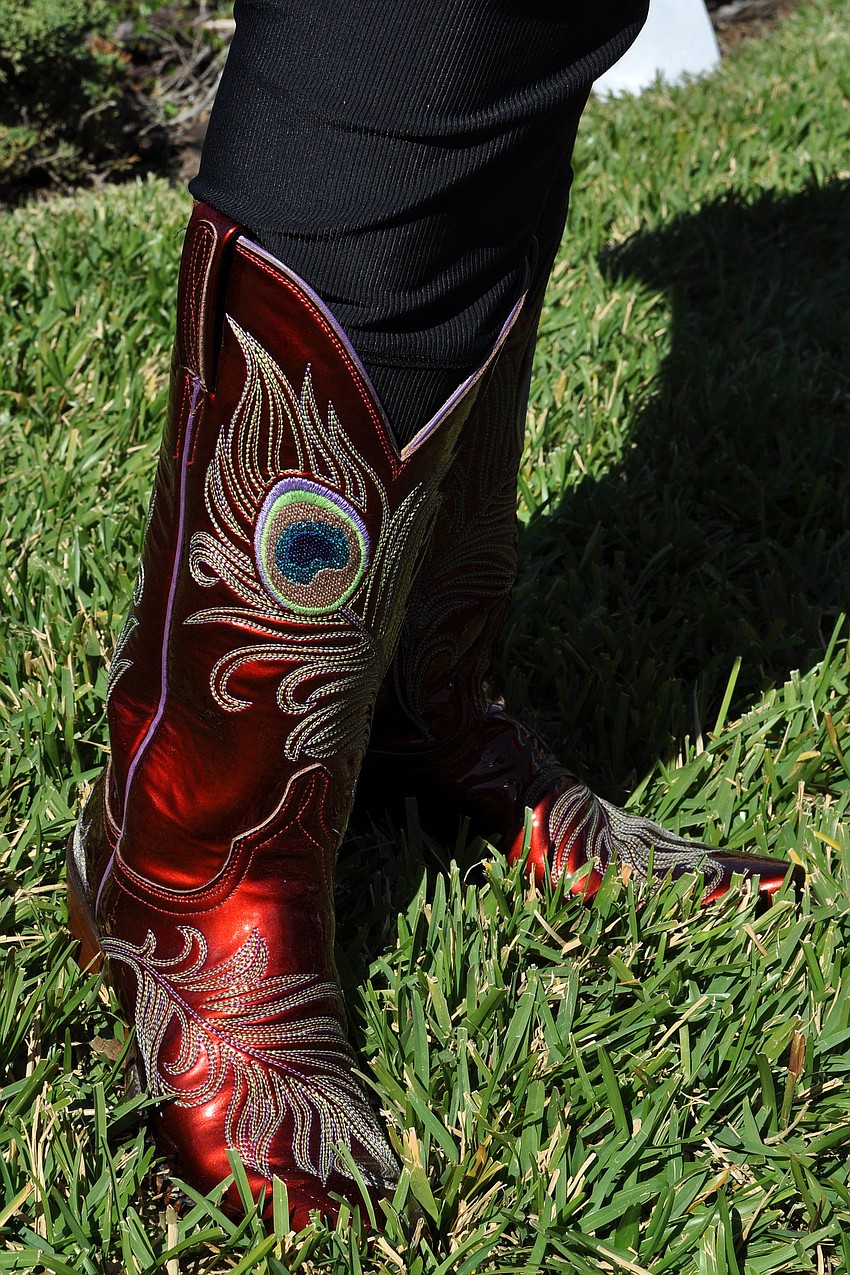 Joanie Corneil wore red cowboy boots decorated with a peacock feather embroidery.