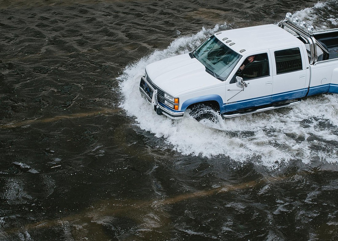 Wade Austin Ellis/Unsplash.com. A driver navigates flooded streets in Jacksonville.
