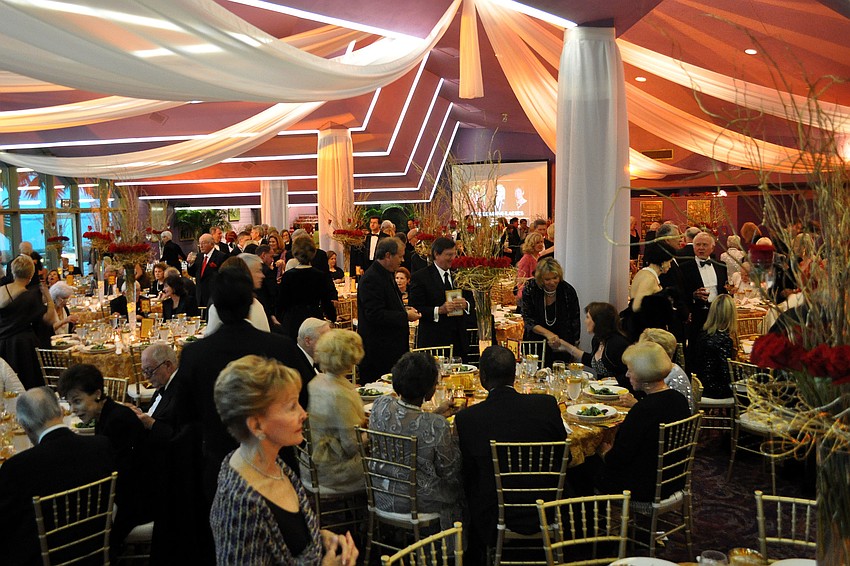The dining area for the guests was decorated elegantly with gold colored chairs, white linens and drapes and ornate rose centerpieces.