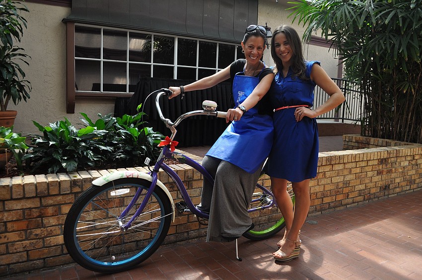 Assunta Swier poses with Christine Sepulveda after winning the beach cruiser raffle prize.