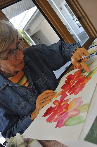 Carol Marcus paints orchids.