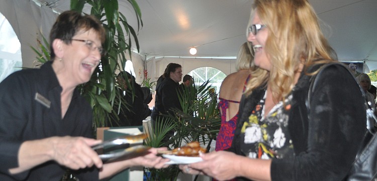 Gale Mills serves lollipop lamb chops to Pam Hagan.
