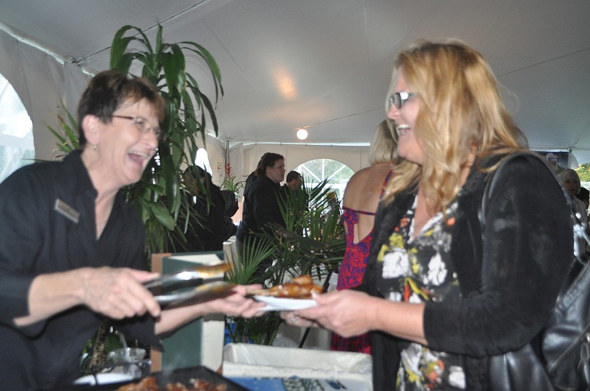 Gale Mills serves lollipop lamb chops to Pam Hagan.