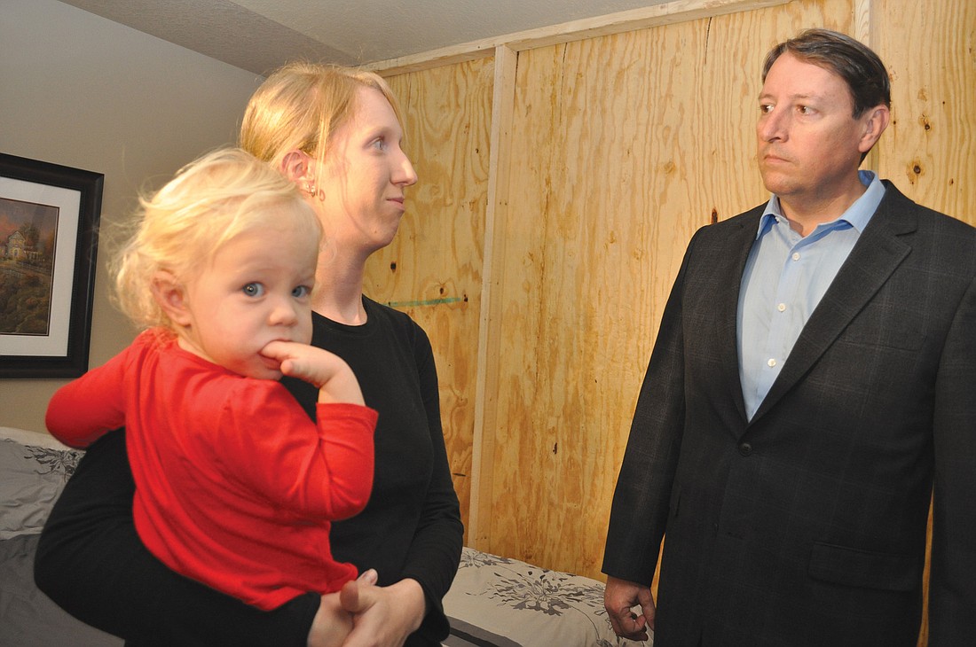 Ashley Delph, holding her daughter, Haley, tells Florida Sen. Bill Galvano about concerns she has with repairs being done on her Willowbrook home.